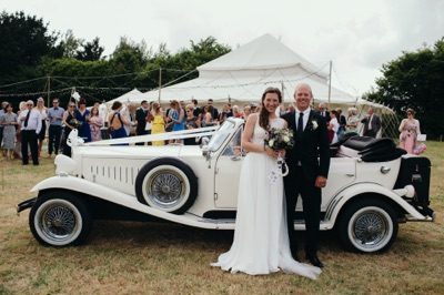 Bride and Groom with wedding car